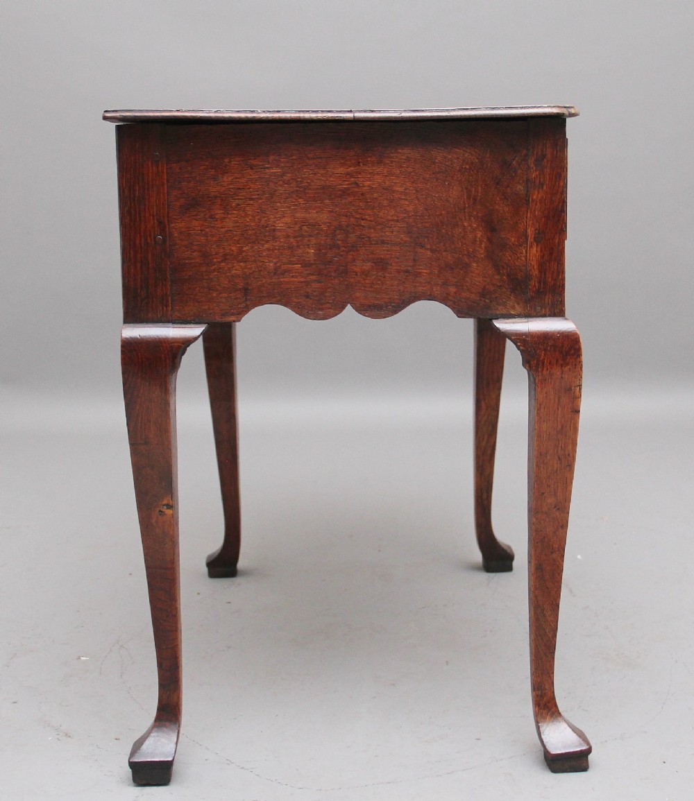 An 18th-century oak lowboy table featuring three drawers with brass handles, inlaid chevron borders, a scalloped apron, and four cabriole legs. View V