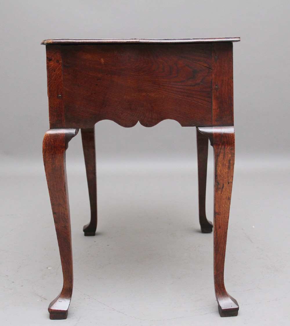 An 18th-century oak lowboy table featuring three drawers with brass handles, inlaid chevron borders, a scalloped apron, and four cabriole legs. View VII