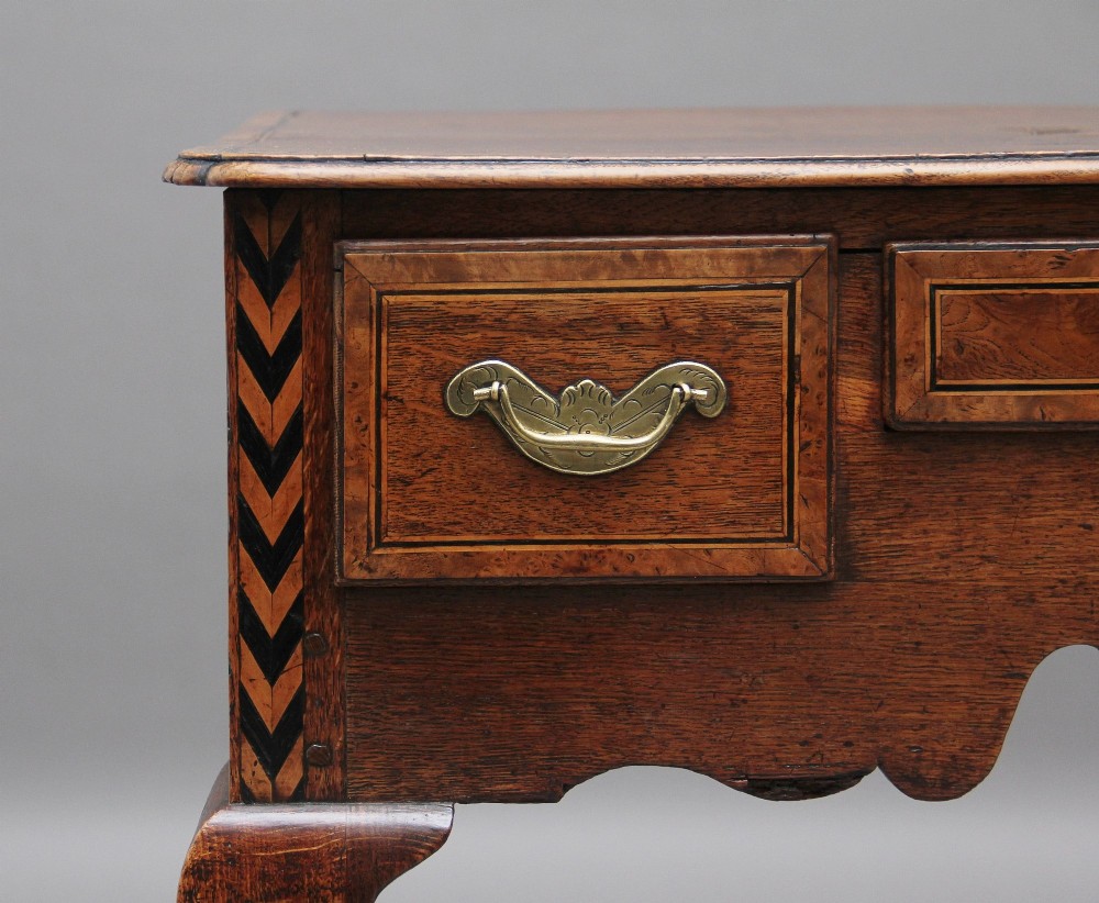 An 18th-century oak lowboy table featuring three drawers with brass handles, inlaid chevron borders, a scalloped apron, and four cabriole legs. View XI