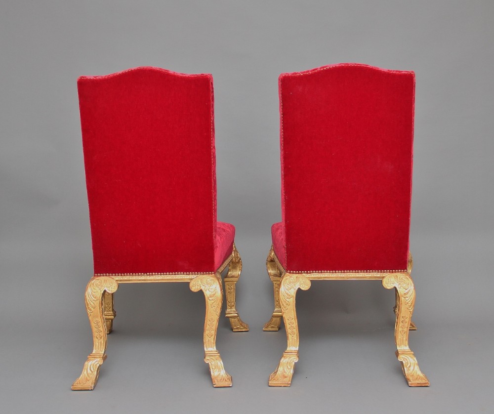 A pair of George I style giltwood side chairs featuring carved mask motifs on the legs and upholstered in rich red patterned velvet. View IV
