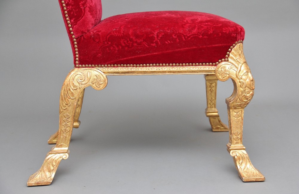 A pair of George I style giltwood side chairs featuring carved mask motifs on the legs and upholstered in rich red patterned velvet. View VIII