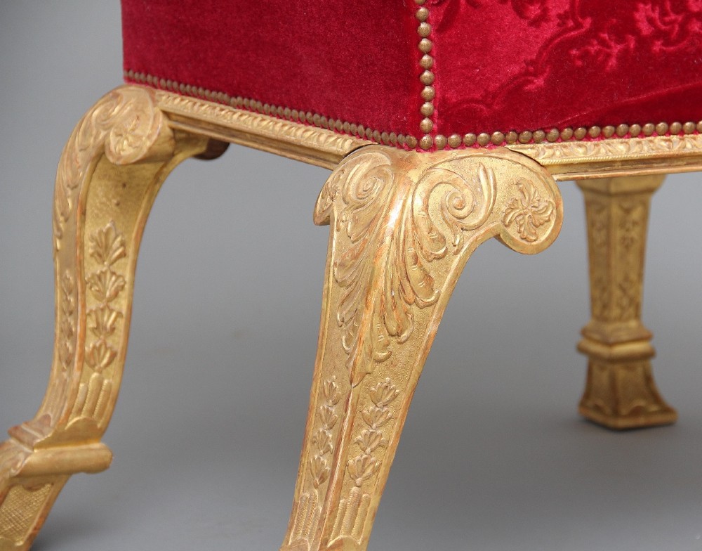 A pair of George I style giltwood side chairs featuring carved mask motifs on the legs and upholstered in rich red patterned velvet. View IX