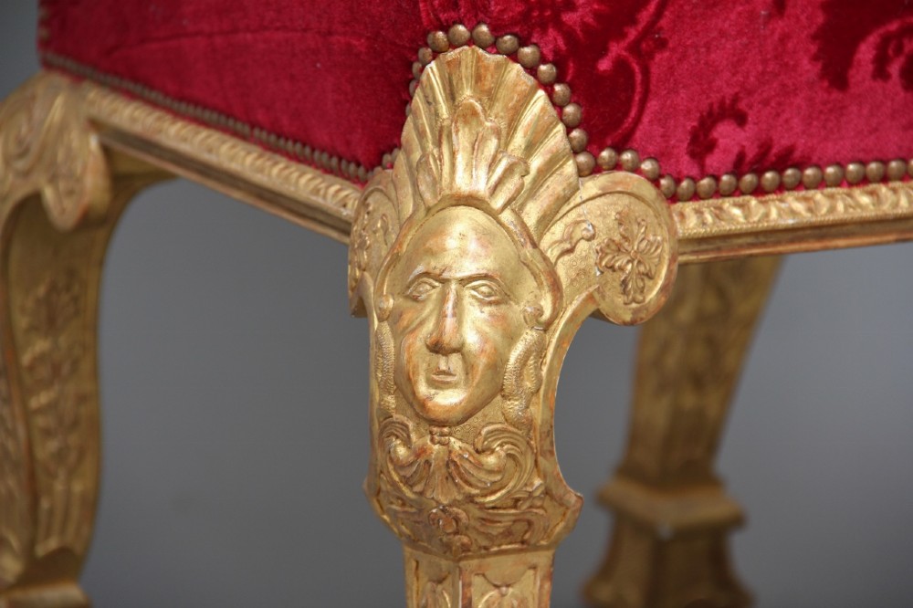 A pair of George I style giltwood side chairs featuring carved mask motifs on the legs and upholstered in rich red patterned velvet. View XIV