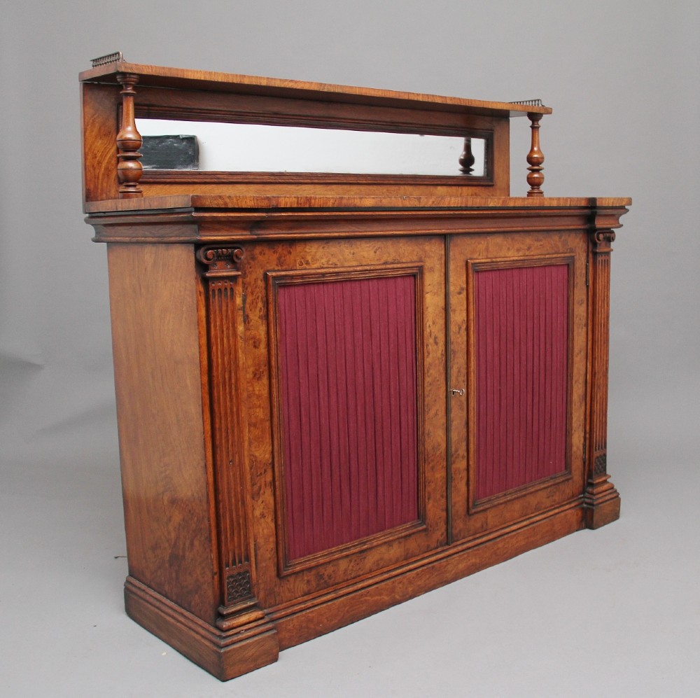 A nineteenth-century pollard oak cabinet featuring a mirrored gallery top, fluted column pillars, and twin doors with fabric-lined panels. View III