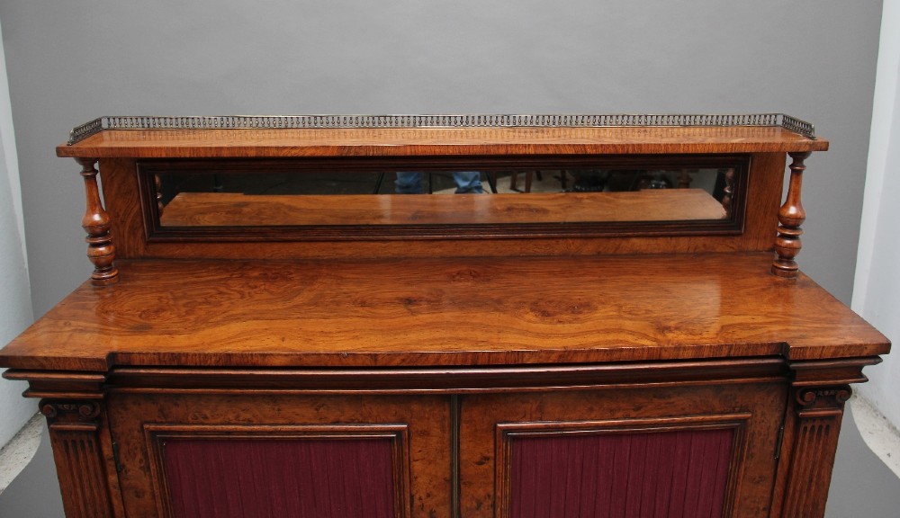 A nineteenth-century pollard oak cabinet featuring a mirrored gallery top, fluted column pillars, and twin doors with fabric-lined panels. View VII