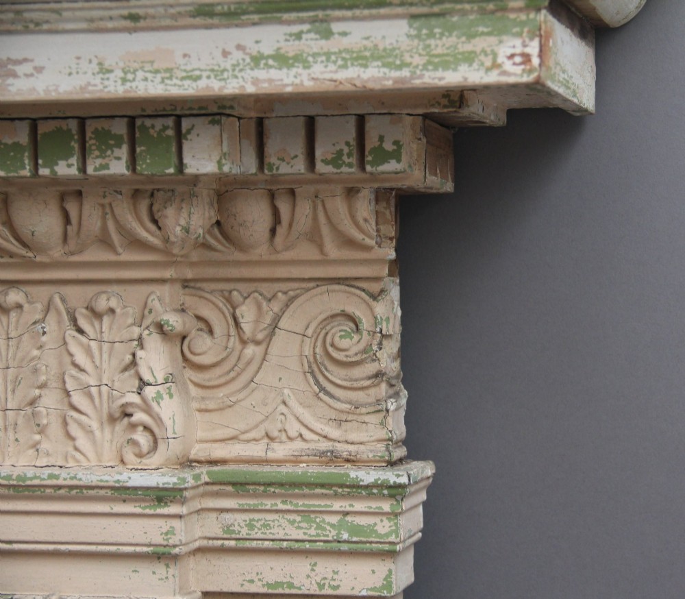 An 18th-century carved pine architectural overmantel featuring a broken pediment, fluted pilasters, dentil mouldings, and a central circular aperture in distressed off-white paint. View VIII