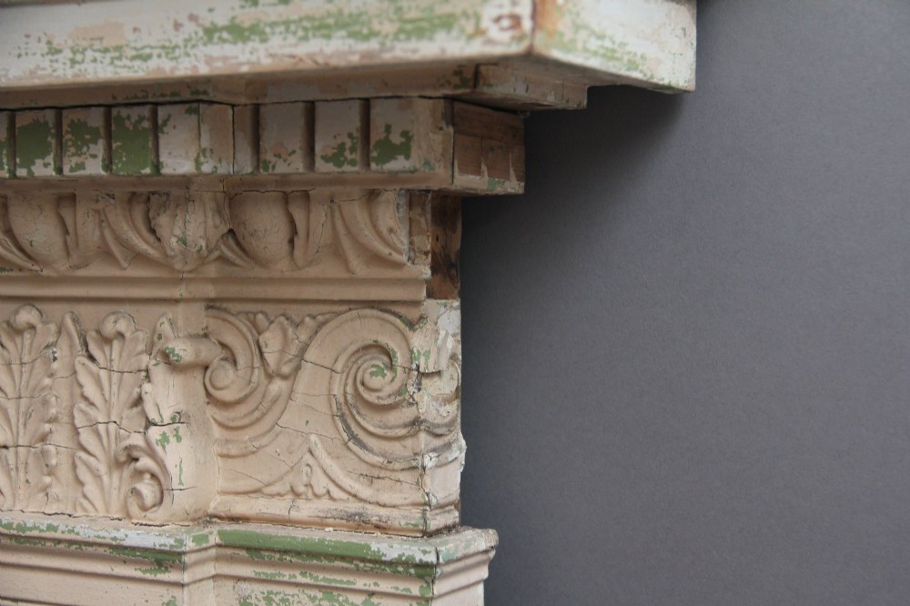 An 18th-century carved pine architectural overmantel featuring a broken pediment, fluted pilasters, dentil mouldings, and a central circular aperture in distressed off-white paint. View IX