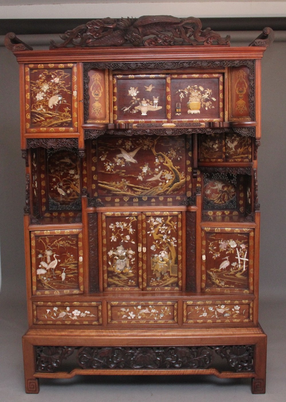 A large 19th-century Japanese hardwood Shodona cabinet featuring asymmetric shelves, carved dragon cresting, and panel doors adorned with lacquer and mother-of-pearl bird motifs. View III