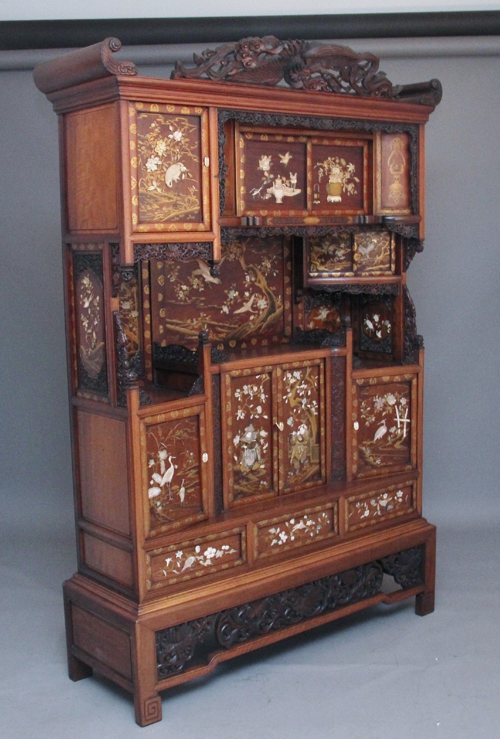 A large 19th-century Japanese hardwood Shodona cabinet featuring asymmetric shelves, carved dragon cresting, and panel doors adorned with lacquer and mother-of-pearl bird motifs. View IV