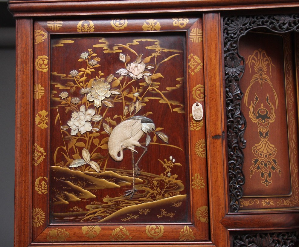 A large 19th-century Japanese hardwood Shodona cabinet featuring asymmetric shelves, carved dragon cresting, and panel doors adorned with lacquer and mother-of-pearl bird motifs. View XII