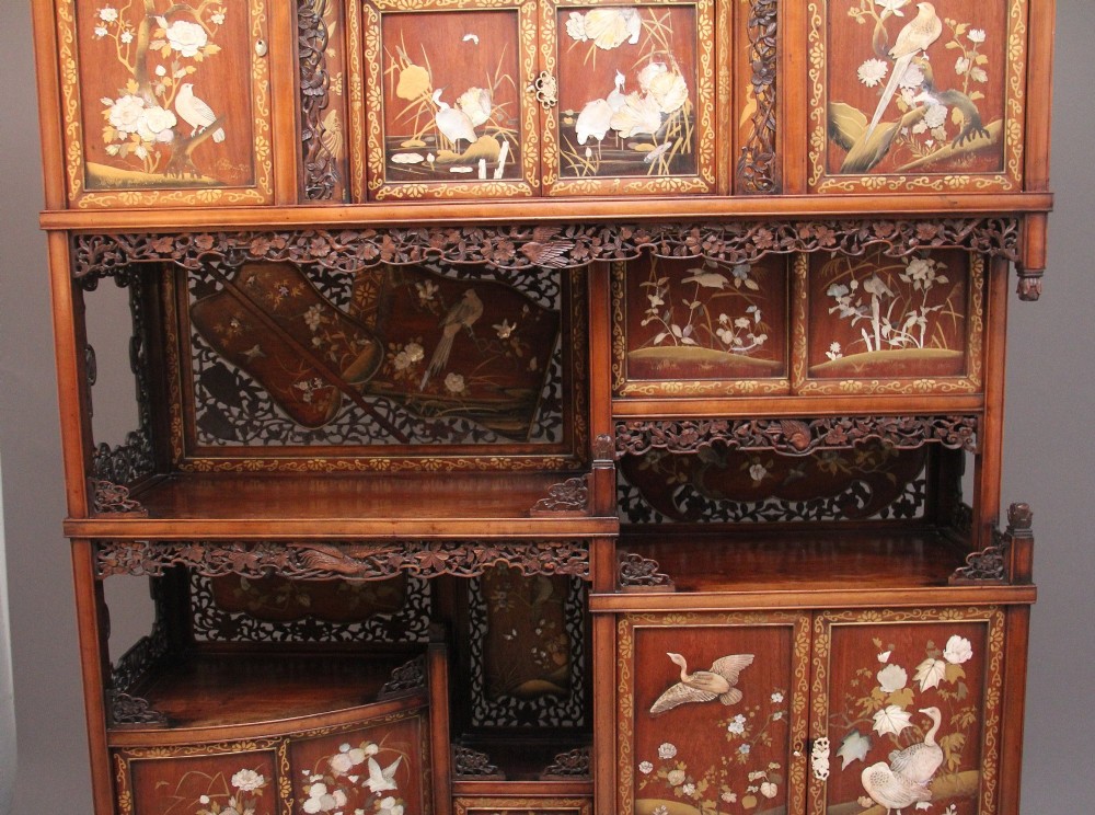 A 19th-century Japanese Meiji period shodona display cabinet with asymmetrical lacquered doors, bird and floral shibayama inlays, and carved cresting. View III