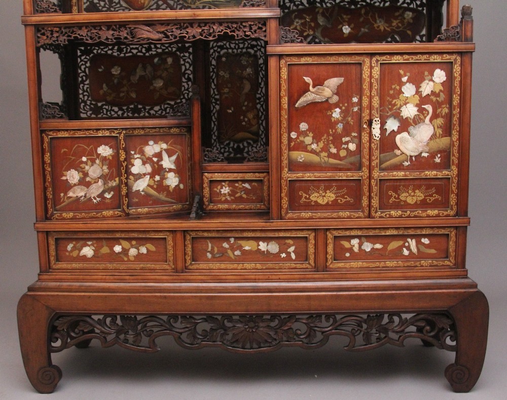 A 19th-century Japanese Meiji period shodona display cabinet with asymmetrical lacquered doors, bird and floral shibayama inlays, and carved cresting. View IX
