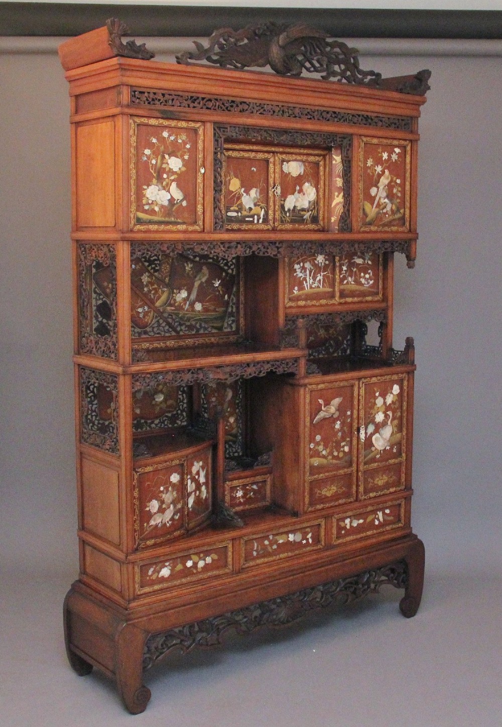 A 19th-century Japanese Meiji period shodona display cabinet with asymmetrical lacquered doors, bird and floral shibayama inlays, and carved cresting. View XI