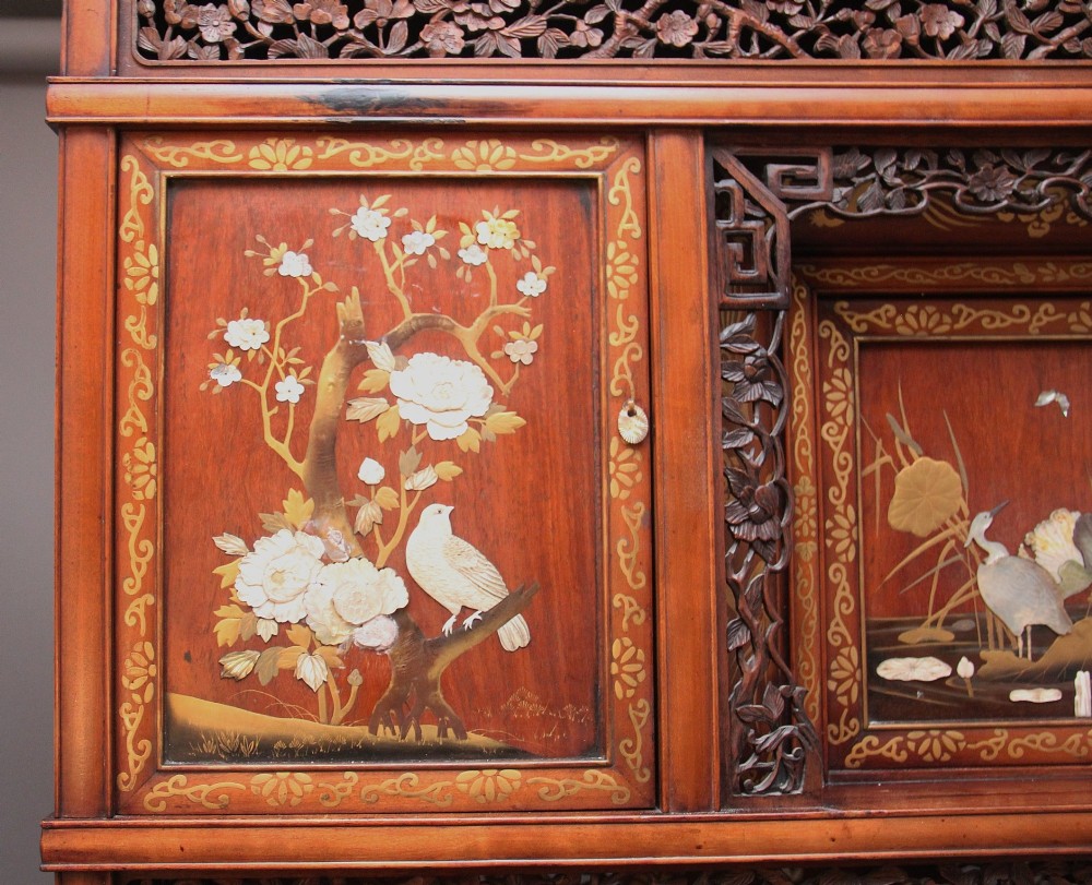 A 19th-century Japanese Meiji period shodona display cabinet with asymmetrical lacquered doors, bird and floral shibayama inlays, and carved cresting. View XV