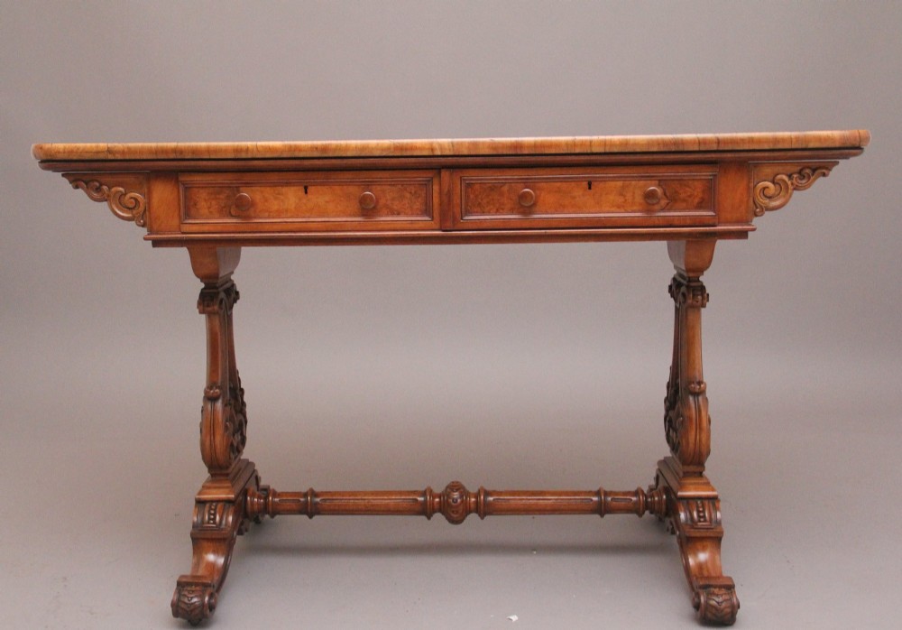 A 19th-century burr walnut library table with two frieze drawers, carved scroll brackets, dual pedestal legs, and a central turned stretcher. View III