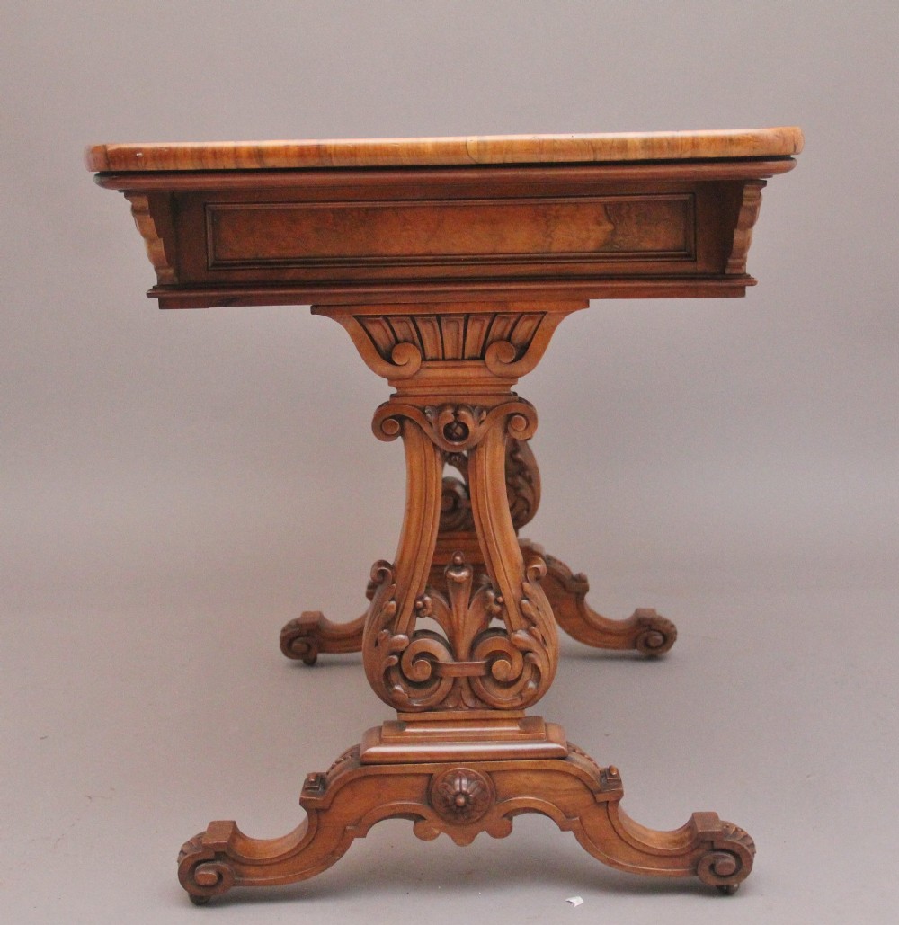 A 19th-century burr walnut library table with two frieze drawers, carved scroll brackets, dual pedestal legs, and a central turned stretcher. View IV