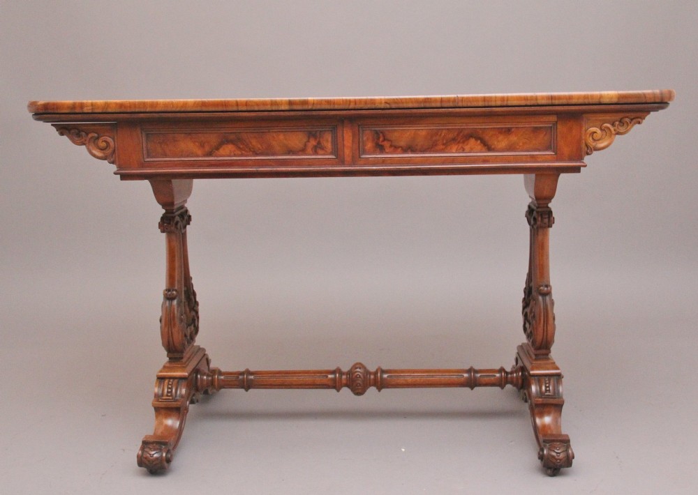 A 19th-century burr walnut library table with two frieze drawers, carved scroll brackets, dual pedestal legs, and a central turned stretcher. View VI