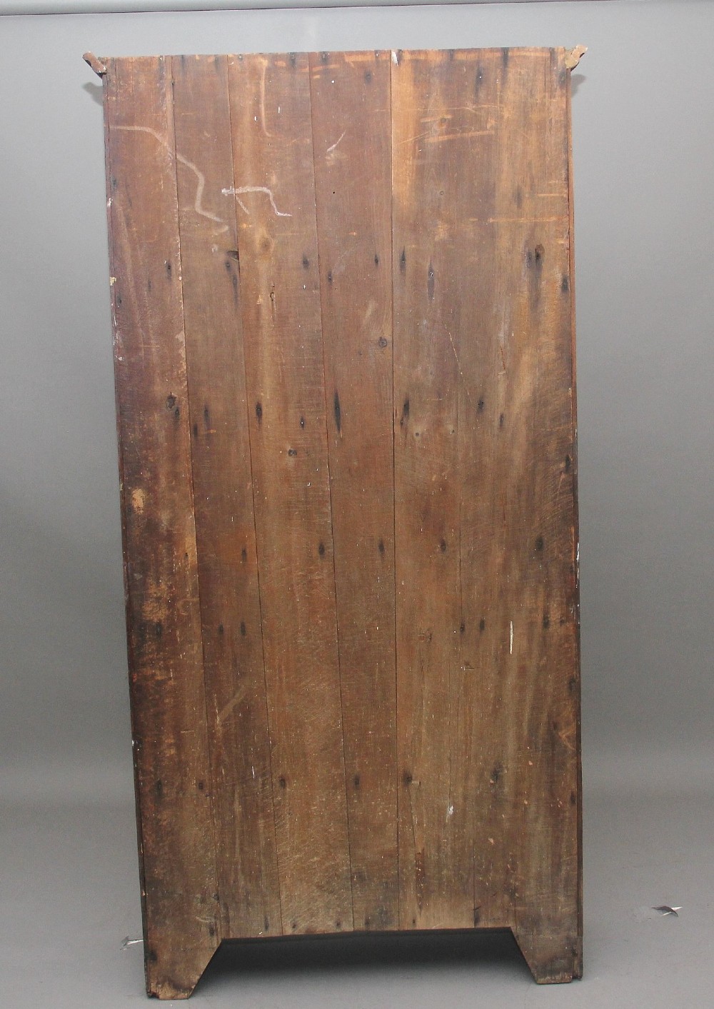 An early 19th-century dark oak food cupboard featuring pierced lattice ventilation panels, brass drawer handles, and panelled double doors. View VI