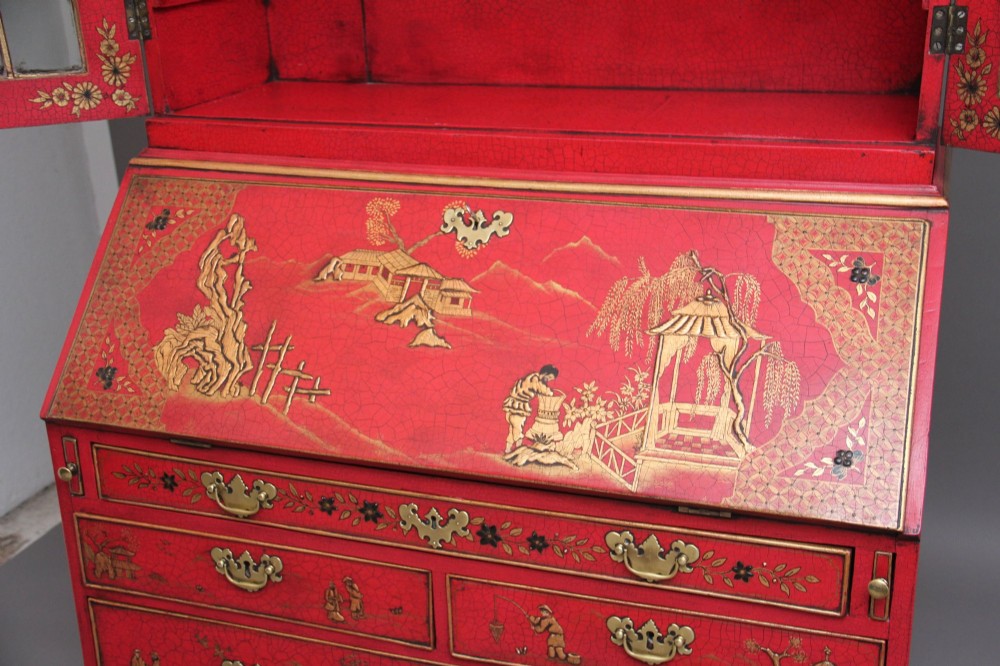 An early twentieth-century red lacquered Chinoiserie bureau bookcase decorated with gilded landscapes, double glazed doors, and brass drop handles. View VII