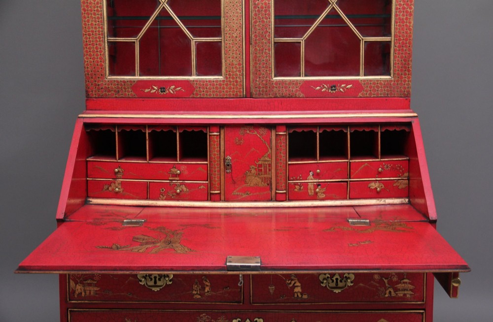 An early twentieth-century red lacquered Chinoiserie bureau bookcase decorated with gilded landscapes, double glazed doors, and brass drop handles. View VIII
