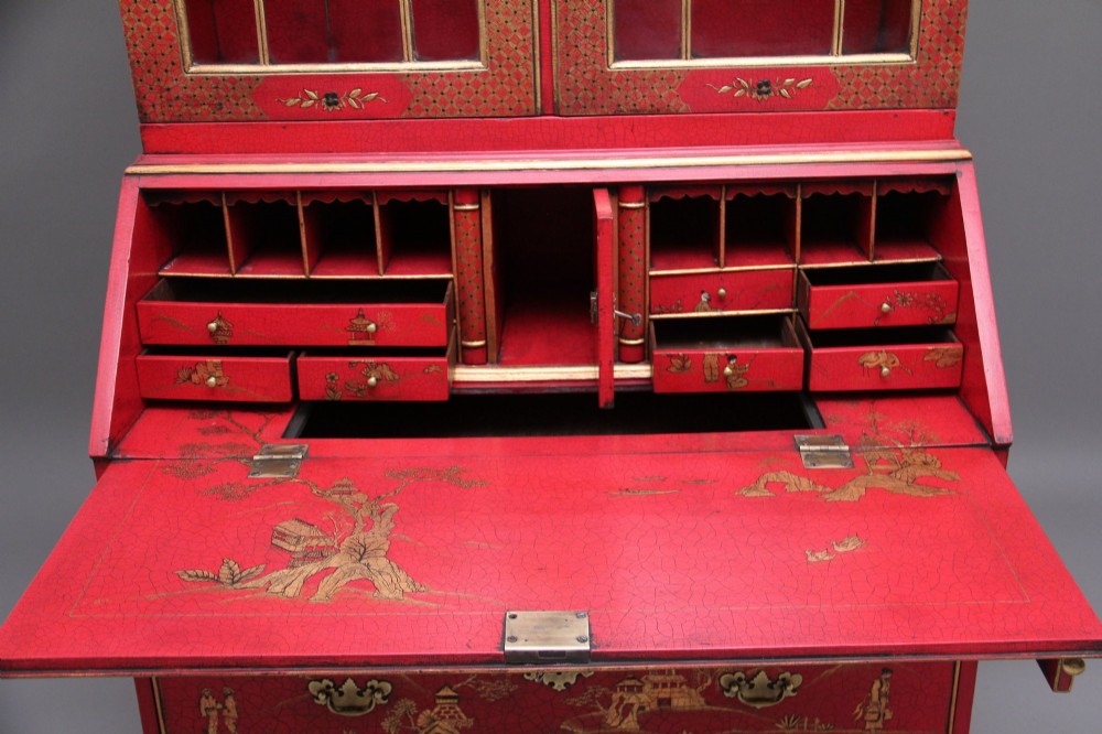 An early twentieth-century red lacquered Chinoiserie bureau bookcase decorated with gilded landscapes, double glazed doors, and brass drop handles. View XI