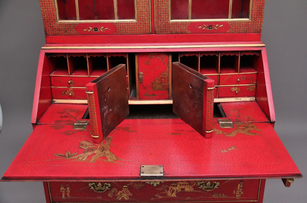 An early twentieth-century red lacquered Chinoiserie bureau bookcase decorated with gilded landscapes, double glazed doors, and brass drop handles. View XII