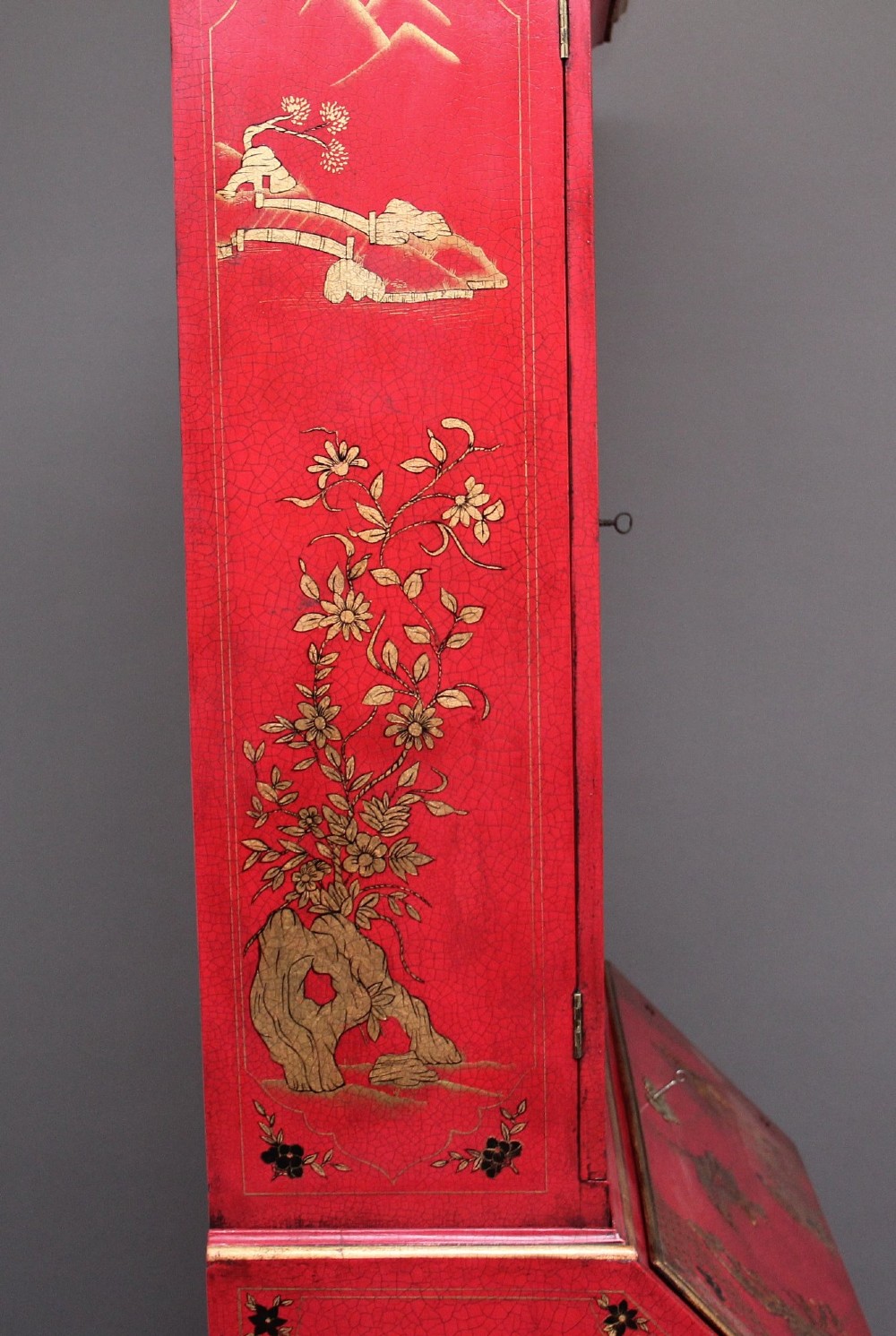 An early twentieth-century red lacquered Chinoiserie bureau bookcase decorated with gilded landscapes, double glazed doors, and brass drop handles. View XV