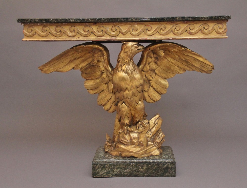 An early 20th-century console table featuring a dark marble top supported by a carved golden eagle pedestal on a matching marble base. View IV