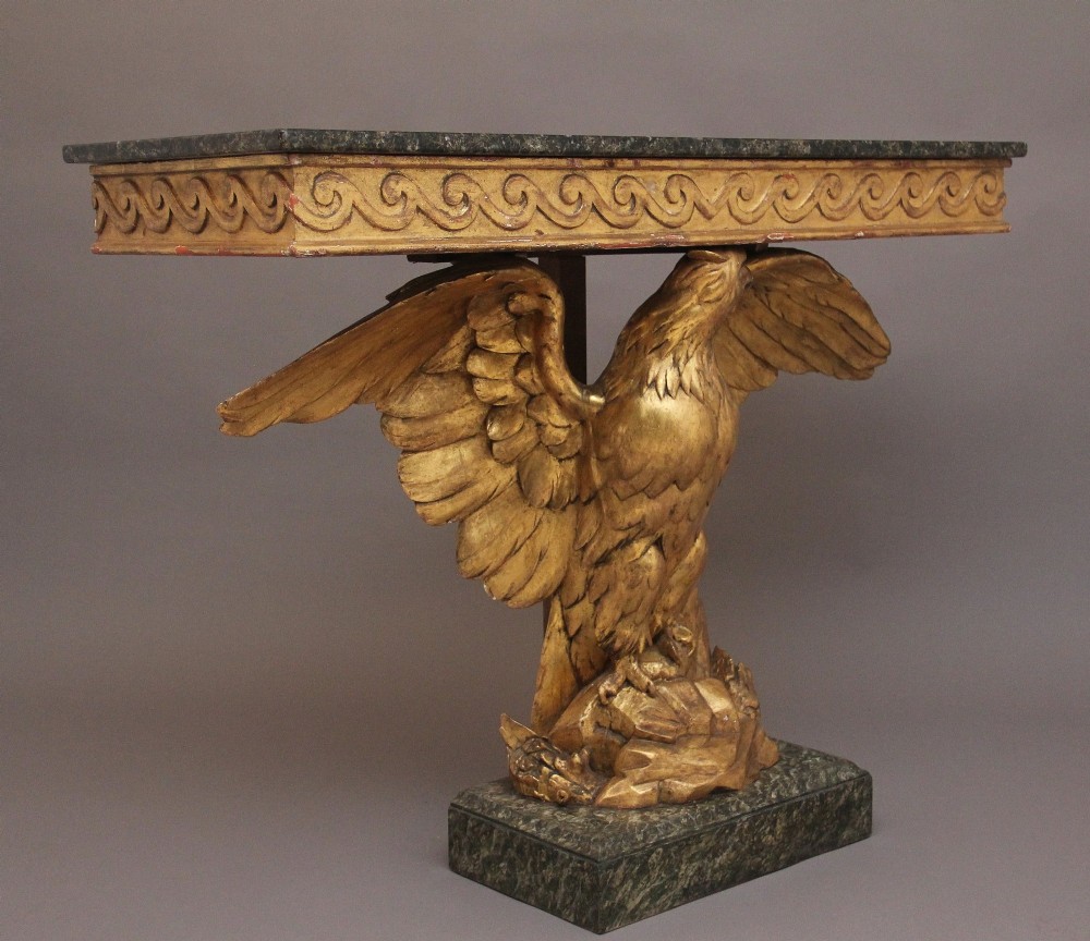 An early 20th-century console table featuring a dark marble top supported by a carved golden eagle pedestal on a matching marble base. View V