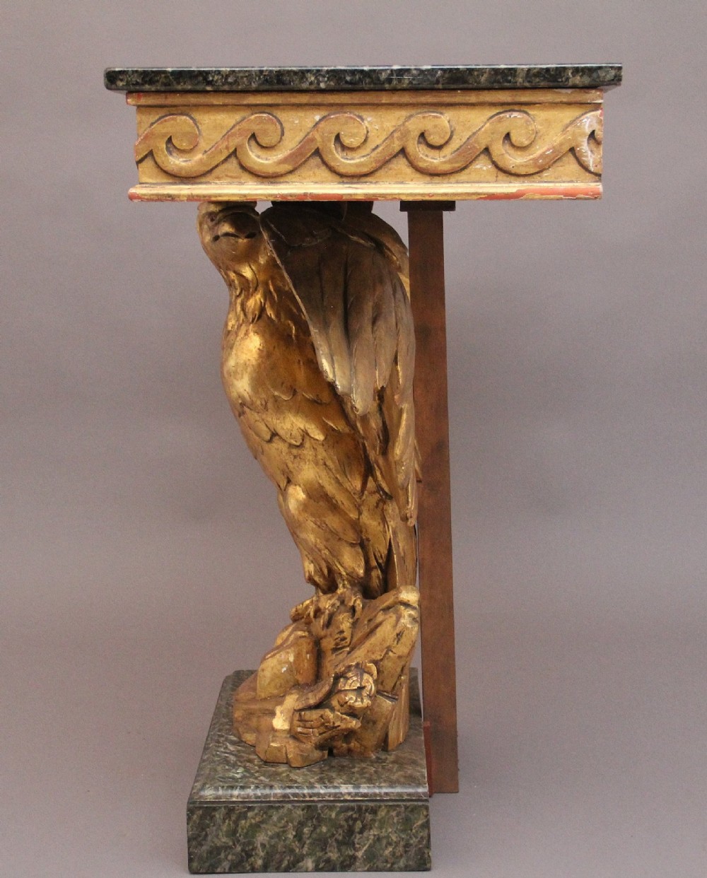An early 20th-century console table featuring a dark marble top supported by a carved golden eagle pedestal on a matching marble base. View VIII