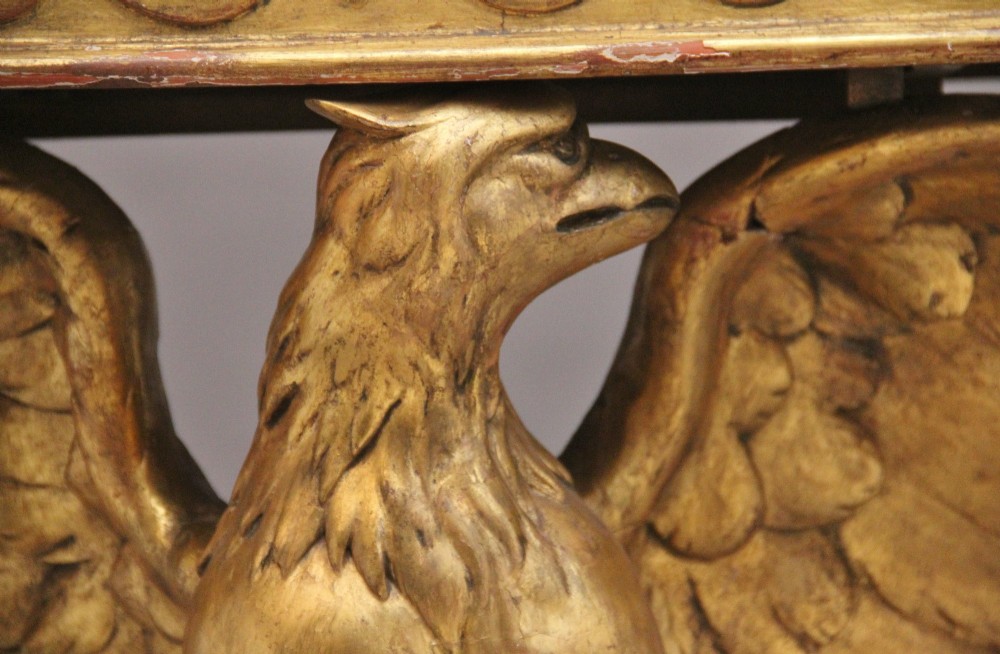 An early 20th-century console table featuring a dark marble top supported by a carved golden eagle pedestal on a matching marble base. View XI