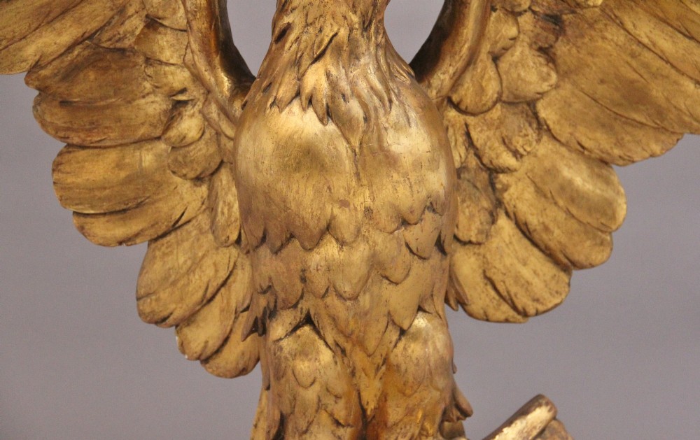 An early 20th-century console table featuring a dark marble top supported by a carved golden eagle pedestal on a matching marble base. View XII