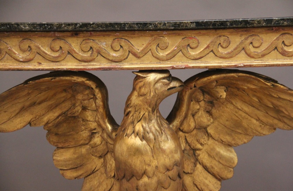 An early 20th-century console table featuring a dark marble top supported by a carved golden eagle pedestal on a matching marble base. View XIV