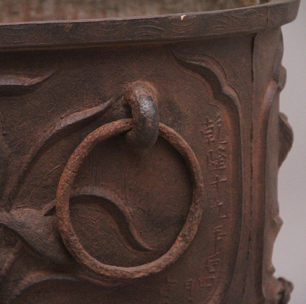 An early nineteenth-century Chinese cast iron temple bath featuring raised floral carvings, side ring handles, and lion mask feet. View X