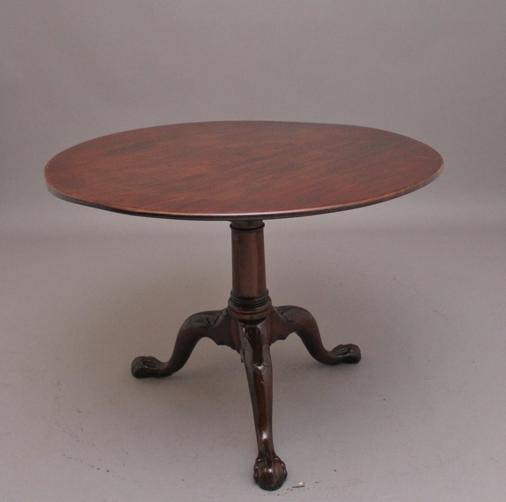 An 18th-century mahogany tripod table with its round top tilted upright on a turned column with three carved legs. View III