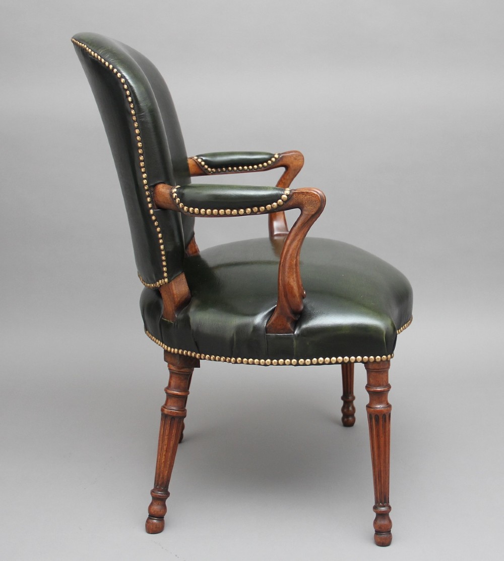 A 19th-century mahogany open armchair upholstered in dark green leather with brass studding and fluted front legs. View III