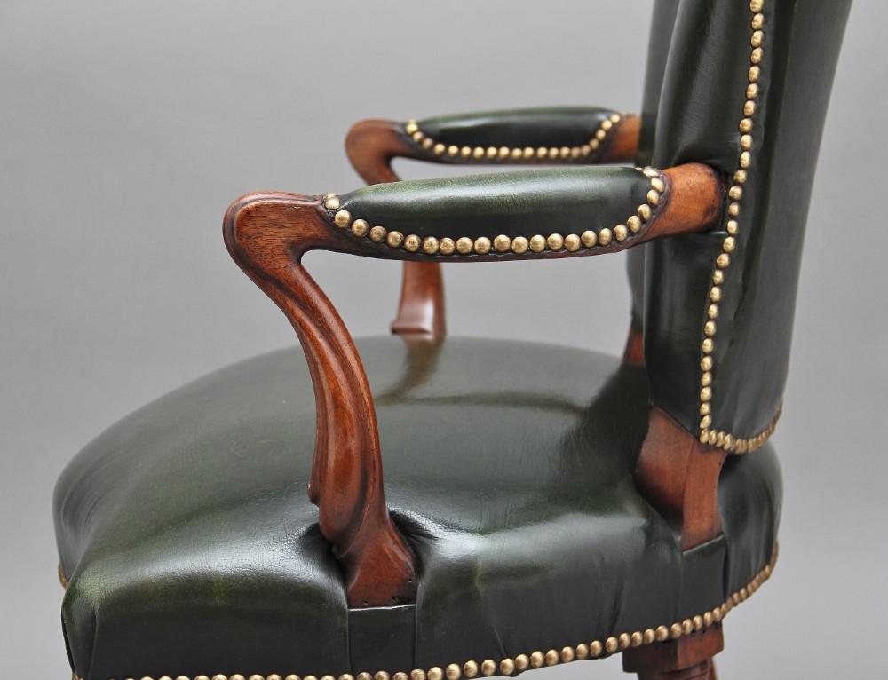A 19th-century mahogany open armchair upholstered in dark green leather with brass studding and fluted front legs. View VI