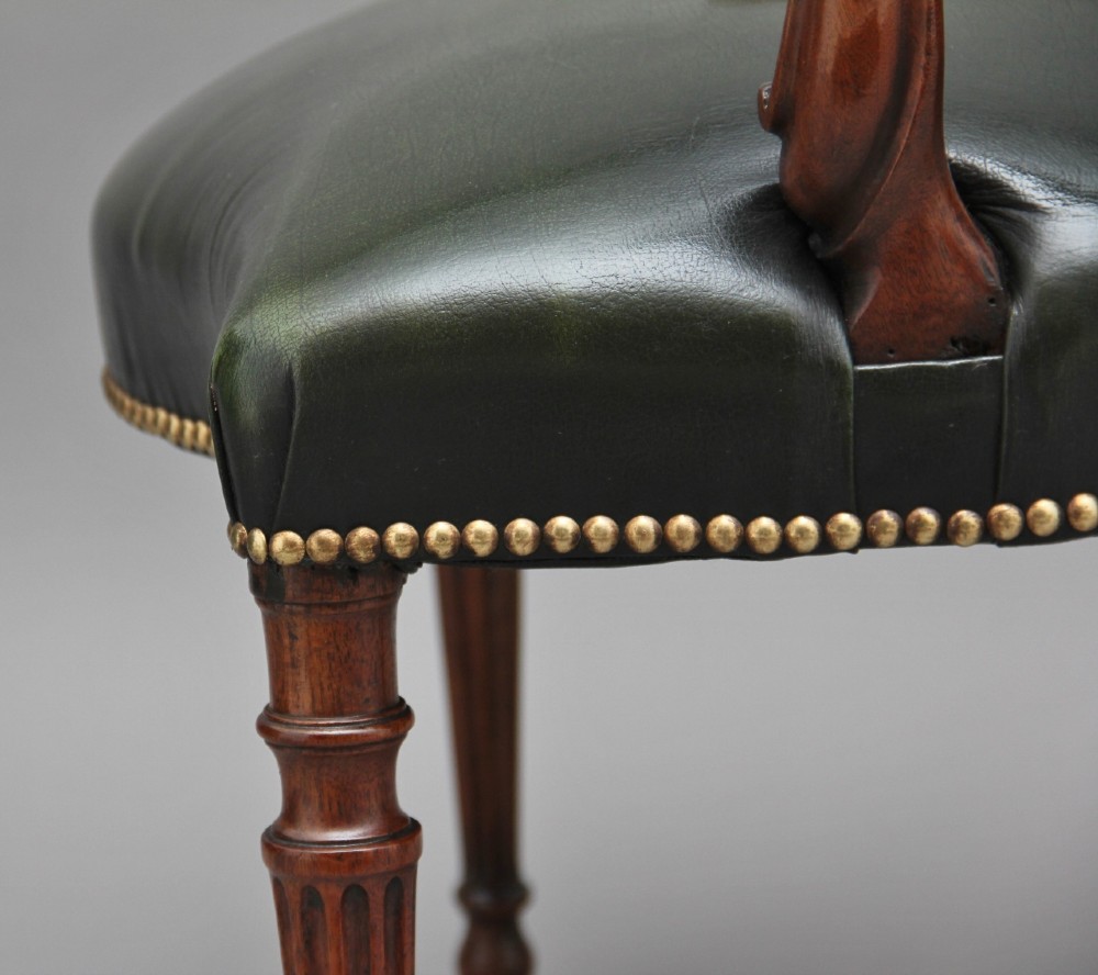 A 19th-century mahogany open armchair upholstered in dark green leather with brass studding and fluted front legs. View VIII