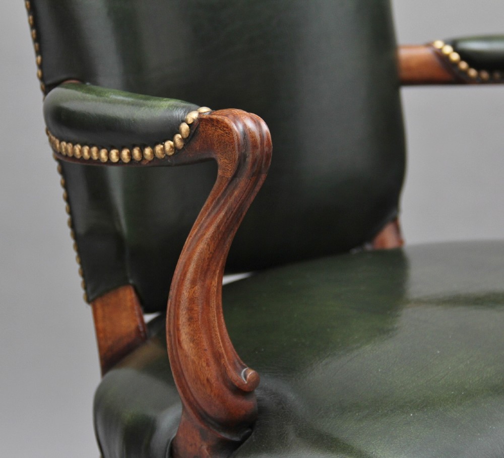 A 19th-century mahogany open armchair upholstered in dark green leather with brass studding and fluted front legs. View IX