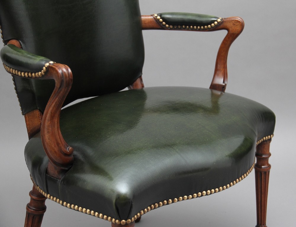 A 19th-century mahogany open armchair upholstered in dark green leather with brass studding and fluted front legs. View XI