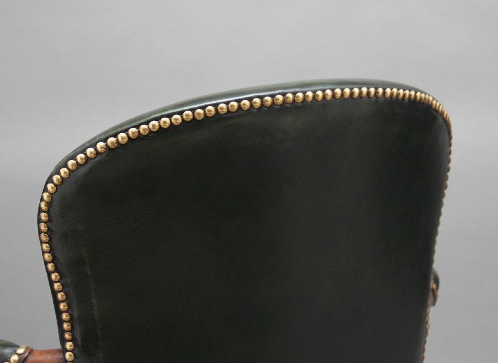 A 19th-century mahogany open armchair upholstered in dark green leather with brass studding and fluted front legs. View XIII