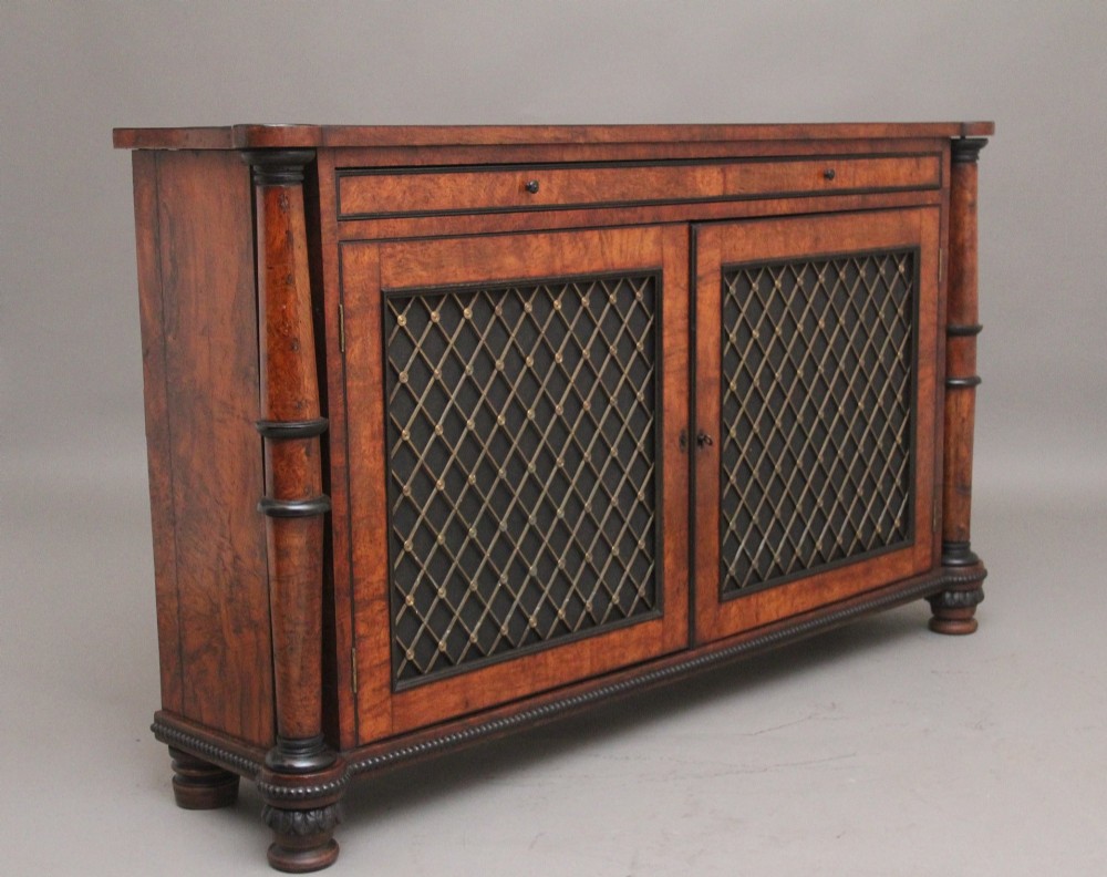 An early 19th-century Regency pollard oak side cabinet featuring two brass lattice grille doors, ebony stringing, and turned flanking columns. View III