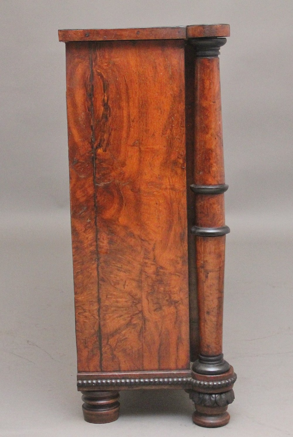 An early 19th-century Regency pollard oak side cabinet featuring two brass lattice grille doors, ebony stringing, and turned flanking columns. View V