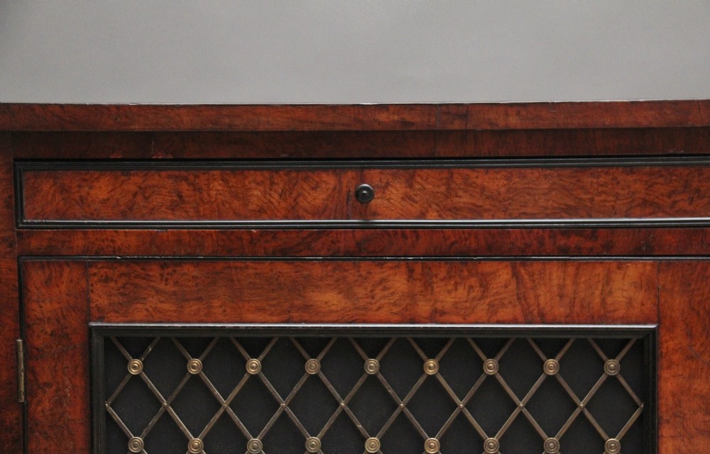 An early 19th-century Regency pollard oak side cabinet featuring two brass lattice grille doors, ebony stringing, and turned flanking columns. View XII