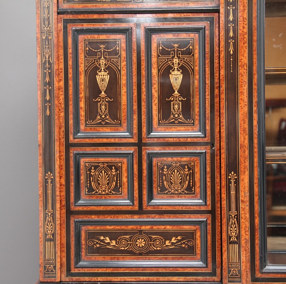 A large Victorian ebonised and walnut display cabinet with marquetry inlays, central glazed doors, and turned columns. View III
