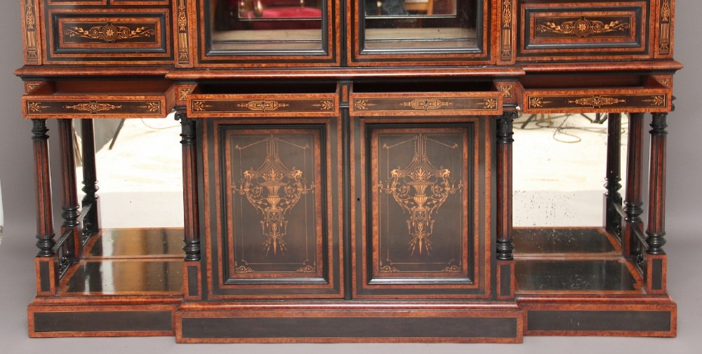 A large Victorian ebonised and walnut display cabinet with marquetry inlays, central glazed doors, and turned columns. View IV
