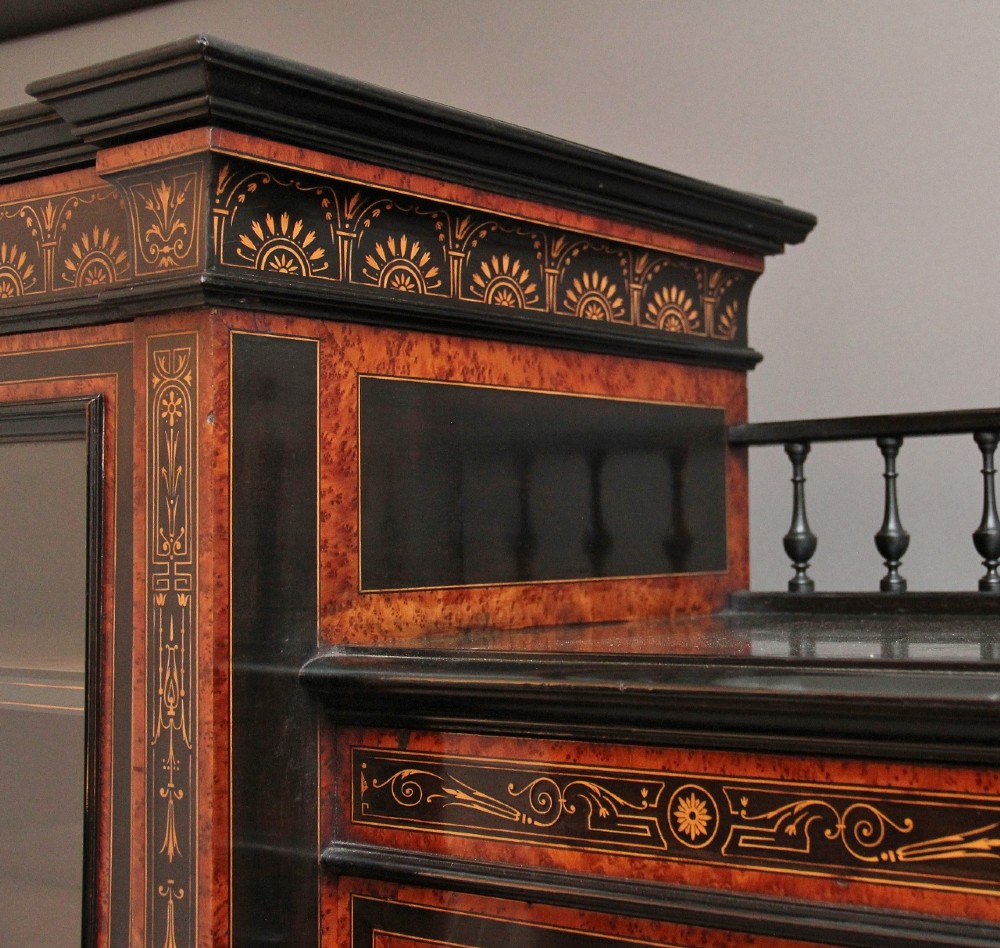 A large Victorian ebonised and walnut display cabinet with marquetry inlays, central glazed doors, and turned columns. View V