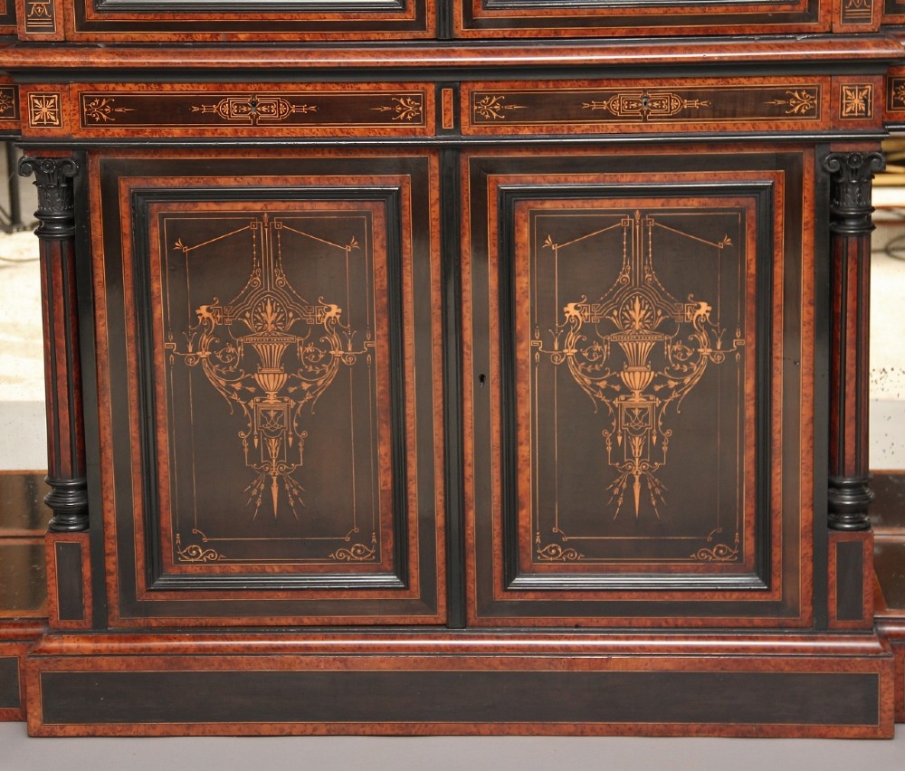 A large Victorian ebonised and walnut display cabinet with marquetry inlays, central glazed doors, and turned columns. View VII