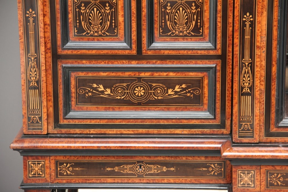 A large Victorian ebonised and walnut display cabinet with marquetry inlays, central glazed doors, and turned columns. View X