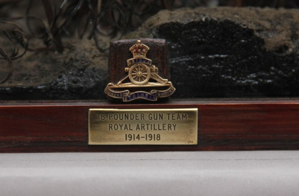 A glazed wooden display case containing an early 20th-century military diorama of a horse-drawn artillery team on a WWI battlefield scene. View II